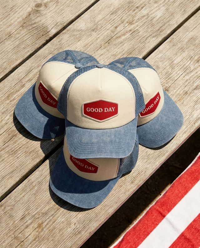 Winning ad: flat-lay of three GOOD DAY trucker caps on a picnic table